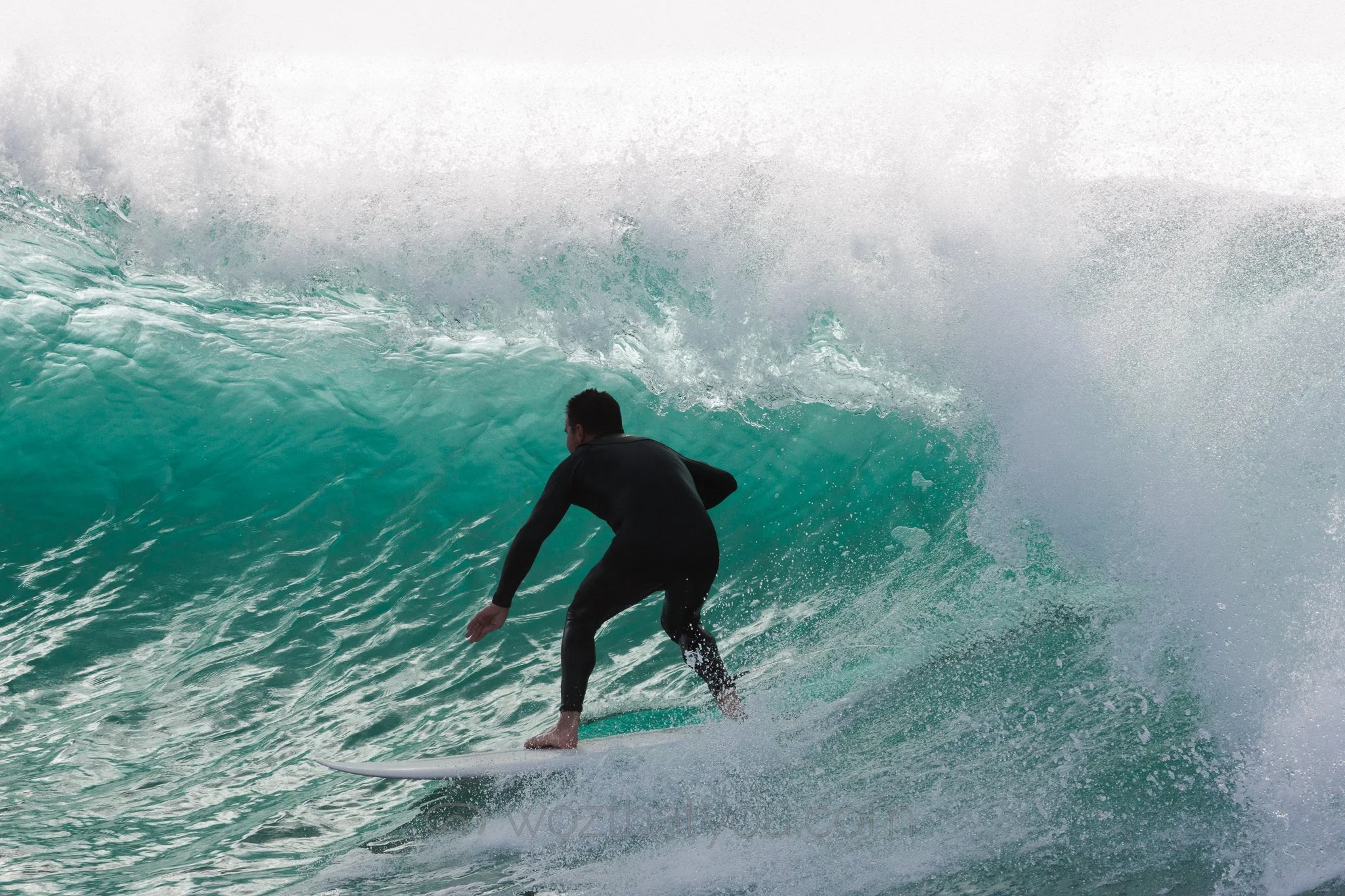 Surfer riding a wave on a surfboard in the ocean.