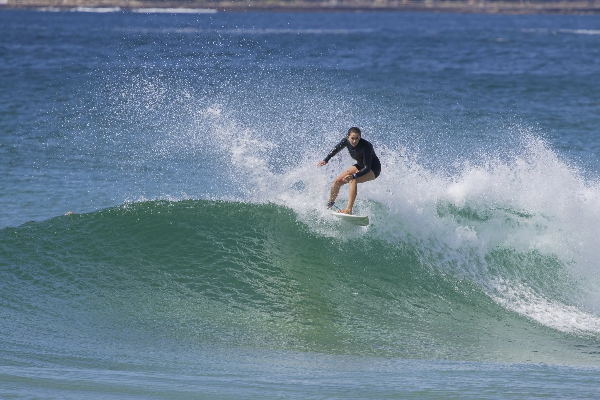 A woman surfing on a wave in the ocean.