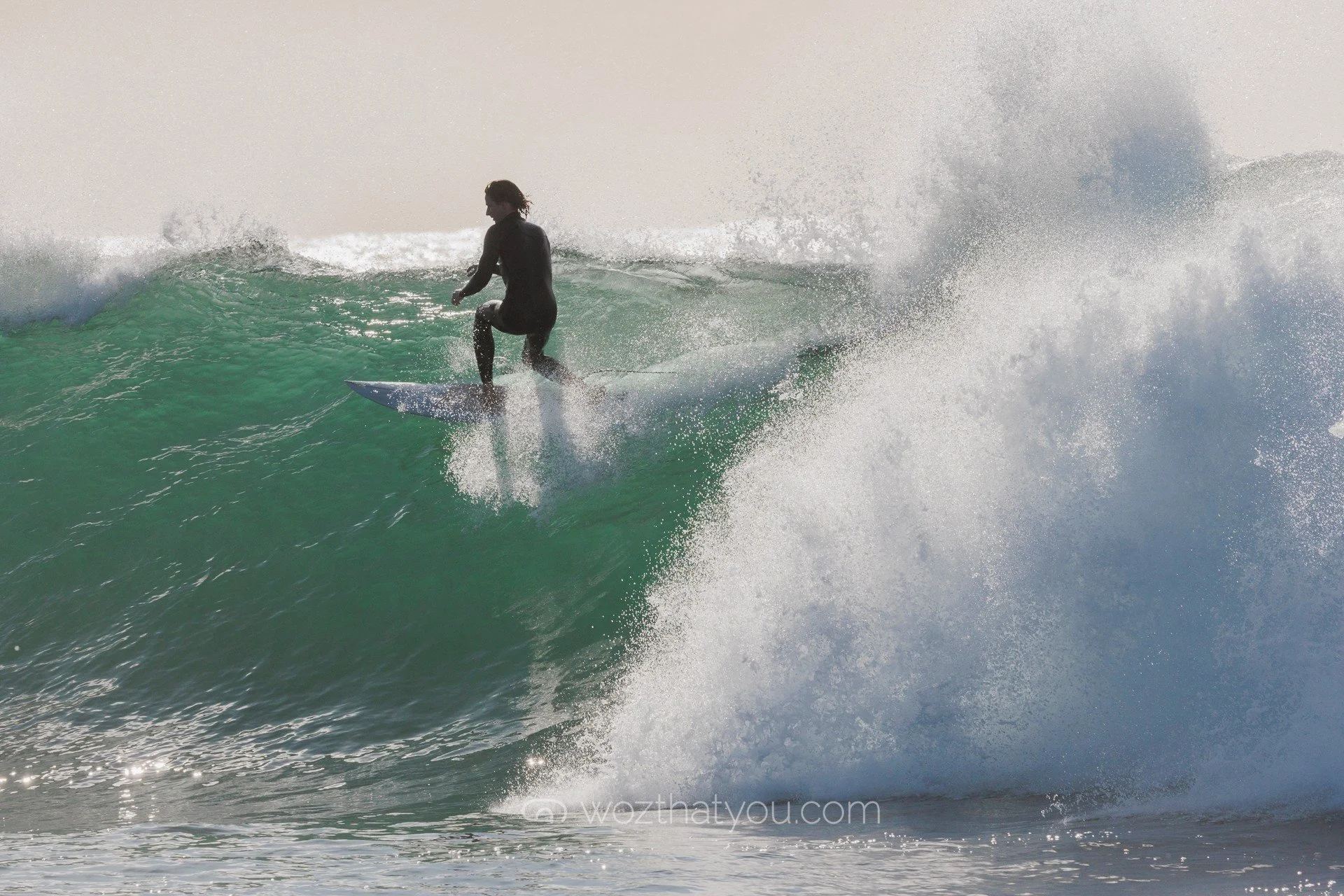 A person surfing on a wave in the ocean during daytime.