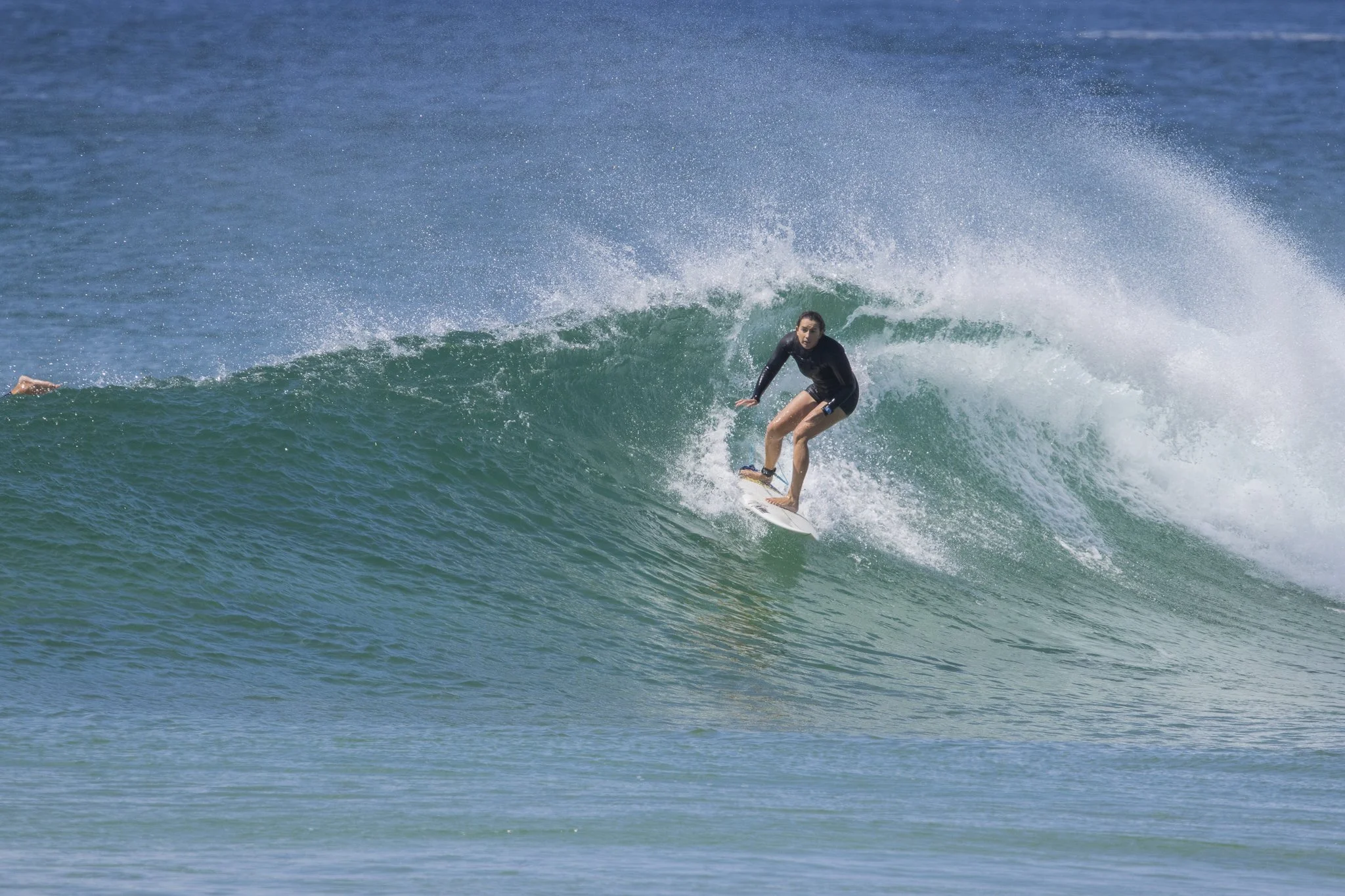 A woman surfing on a green wave in the ocean.