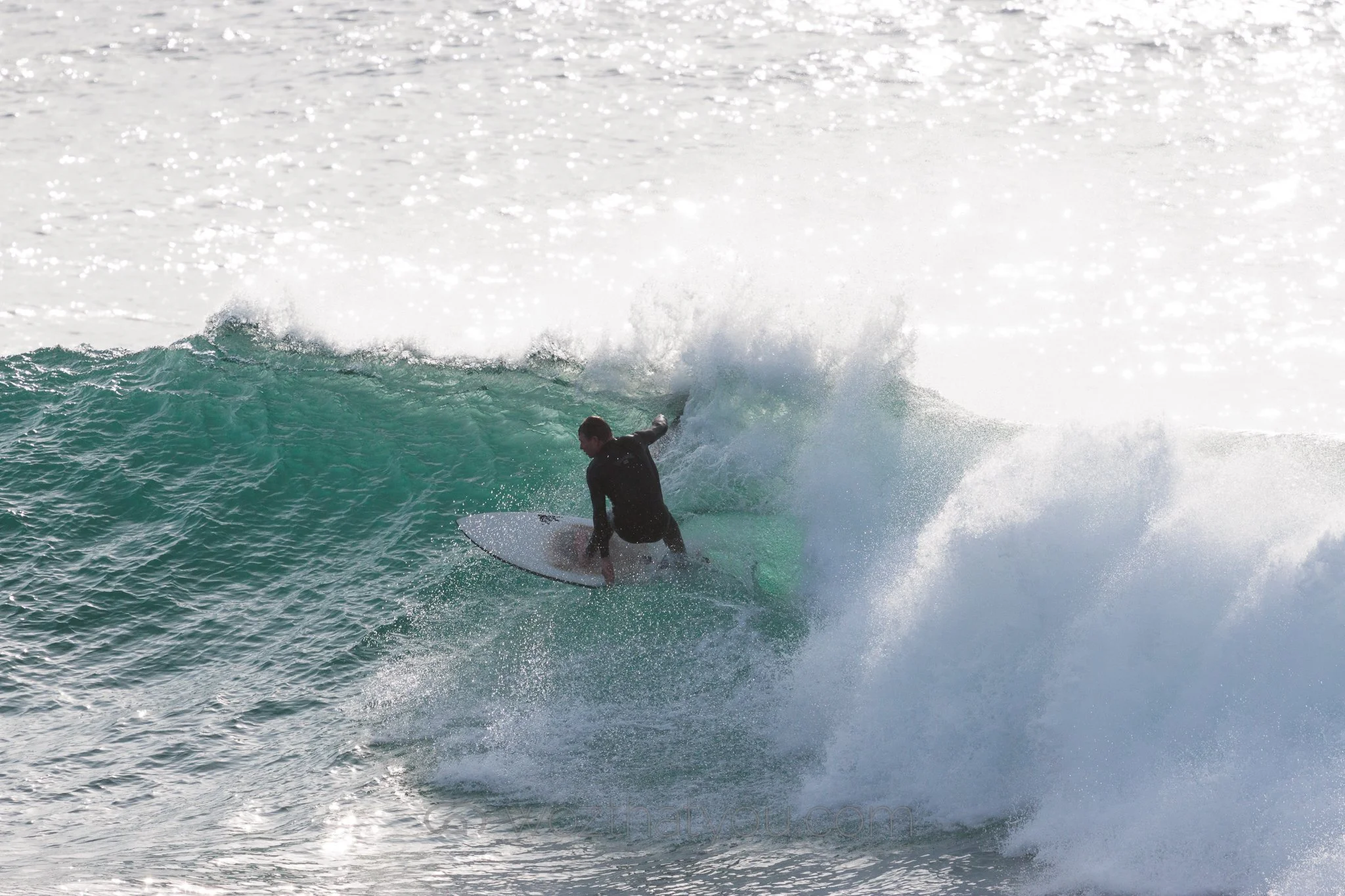 Surfer riding a wave on the ocean during daylight.