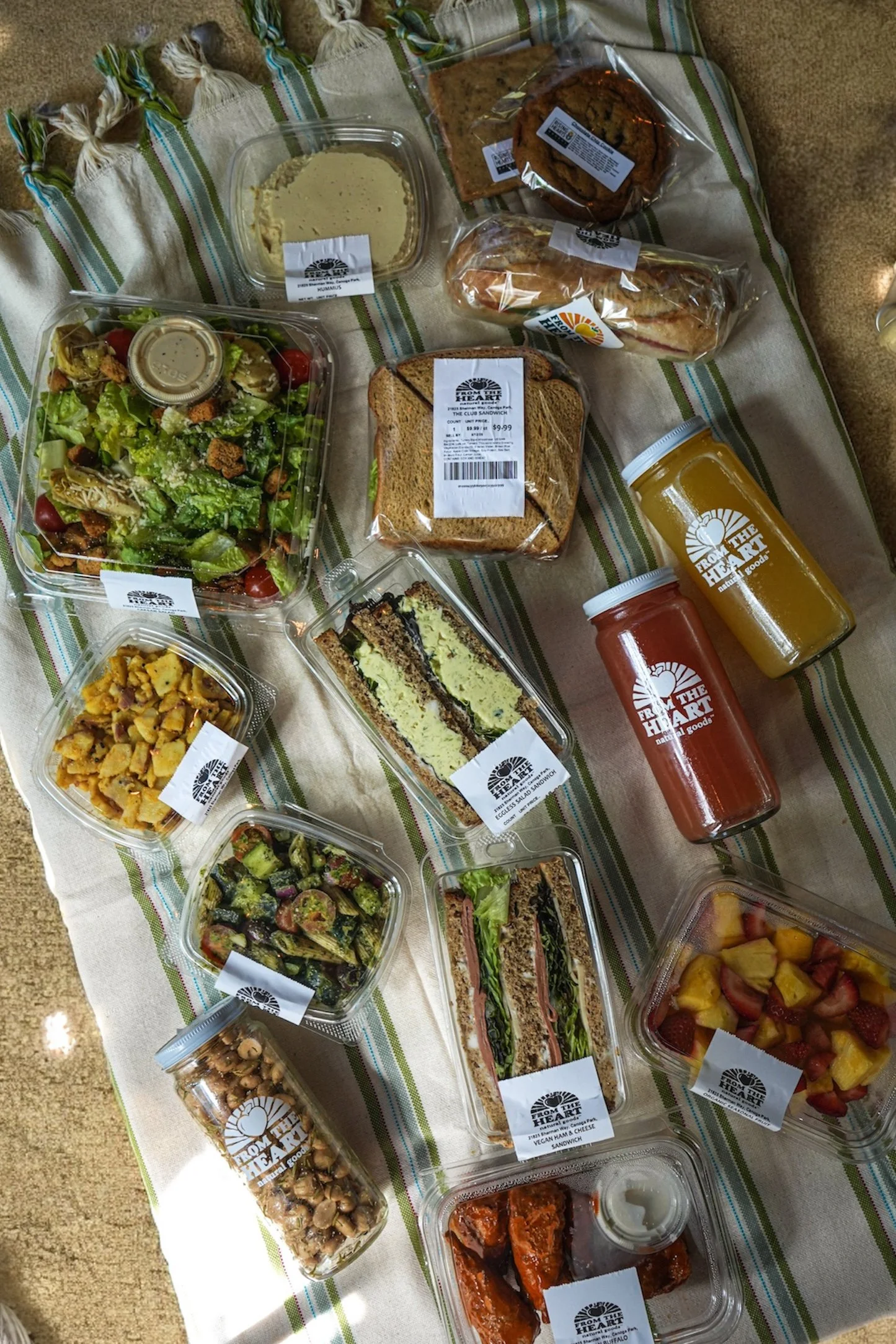 Close-up of a multigrain sandwich with turkey, lettuce, and cheese on a white plate with blurred greenery in the background.