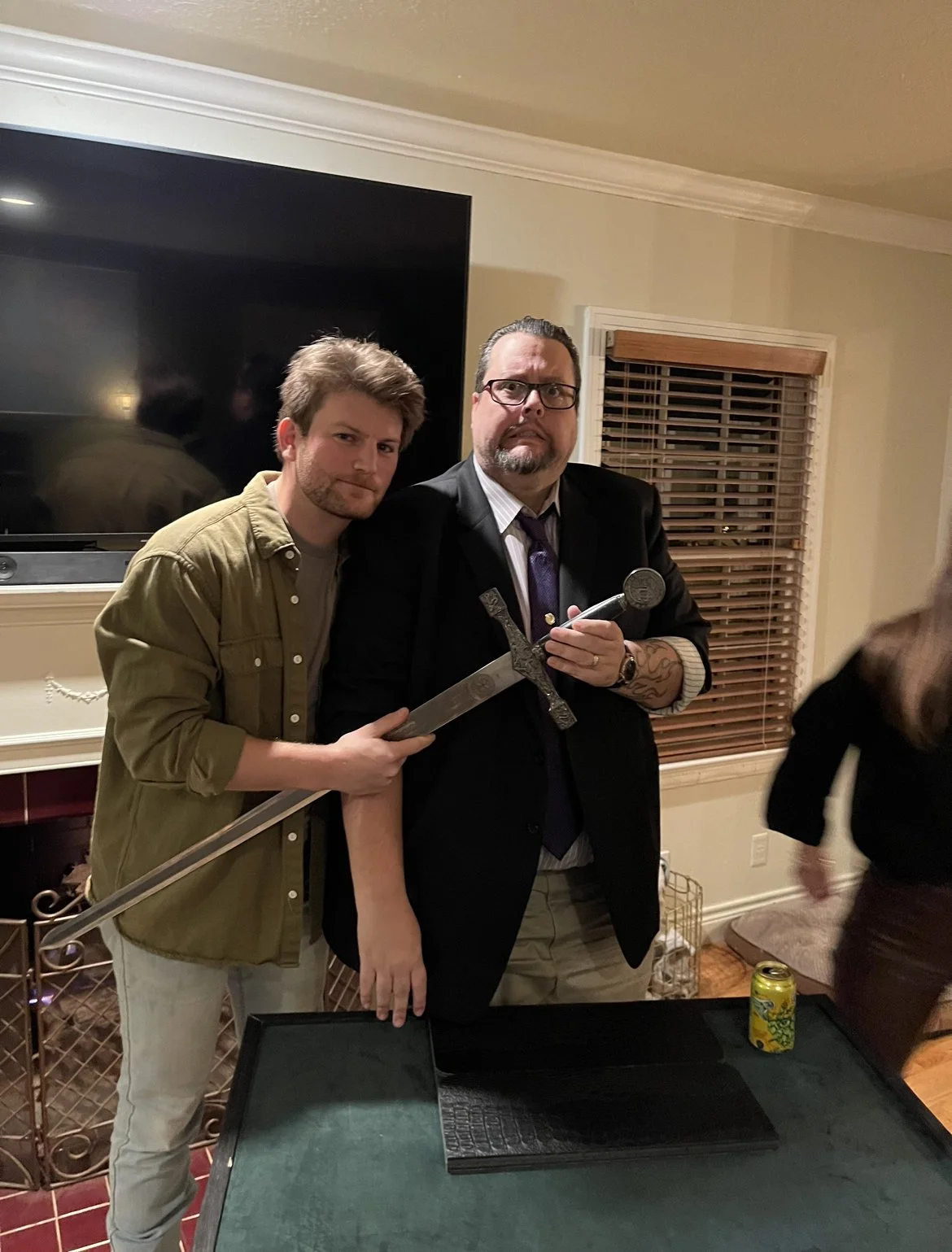 Jeff Walsh taking a photo with an audience member at a private event, while he holds a magic sword