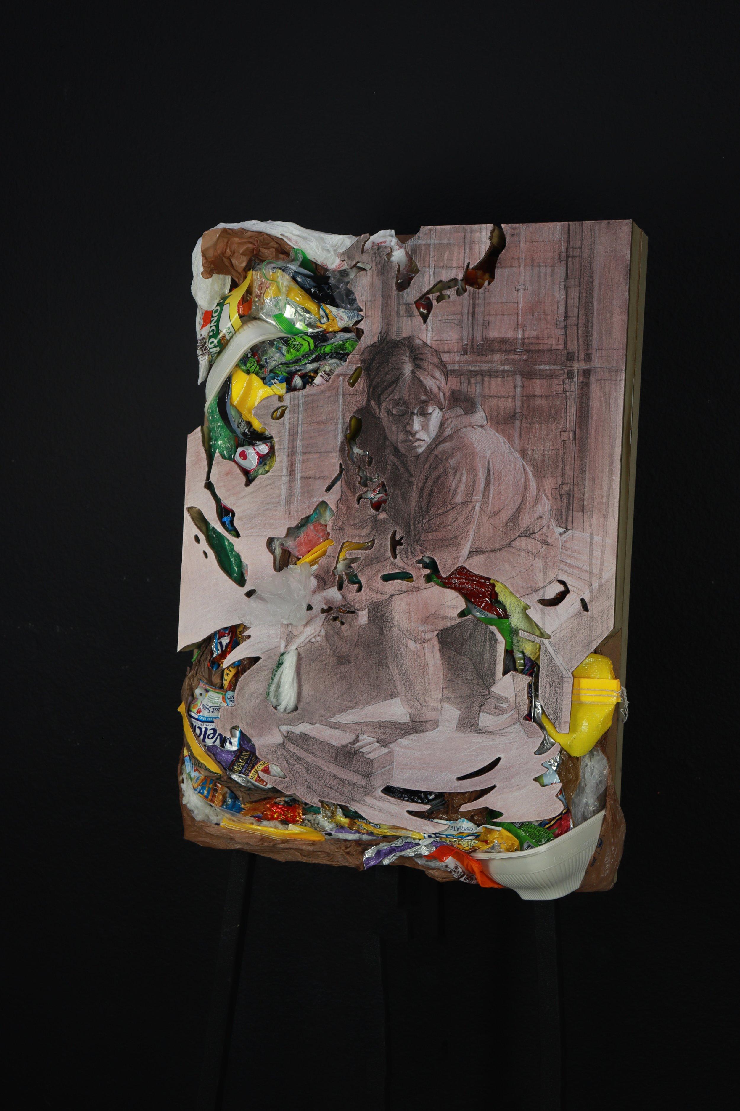 Waste Shipped Away, March 2022, (20.125” x 28”x 3.75”) Charcoal, Conte, Watercolor, Plastic Waste; on MDF board.