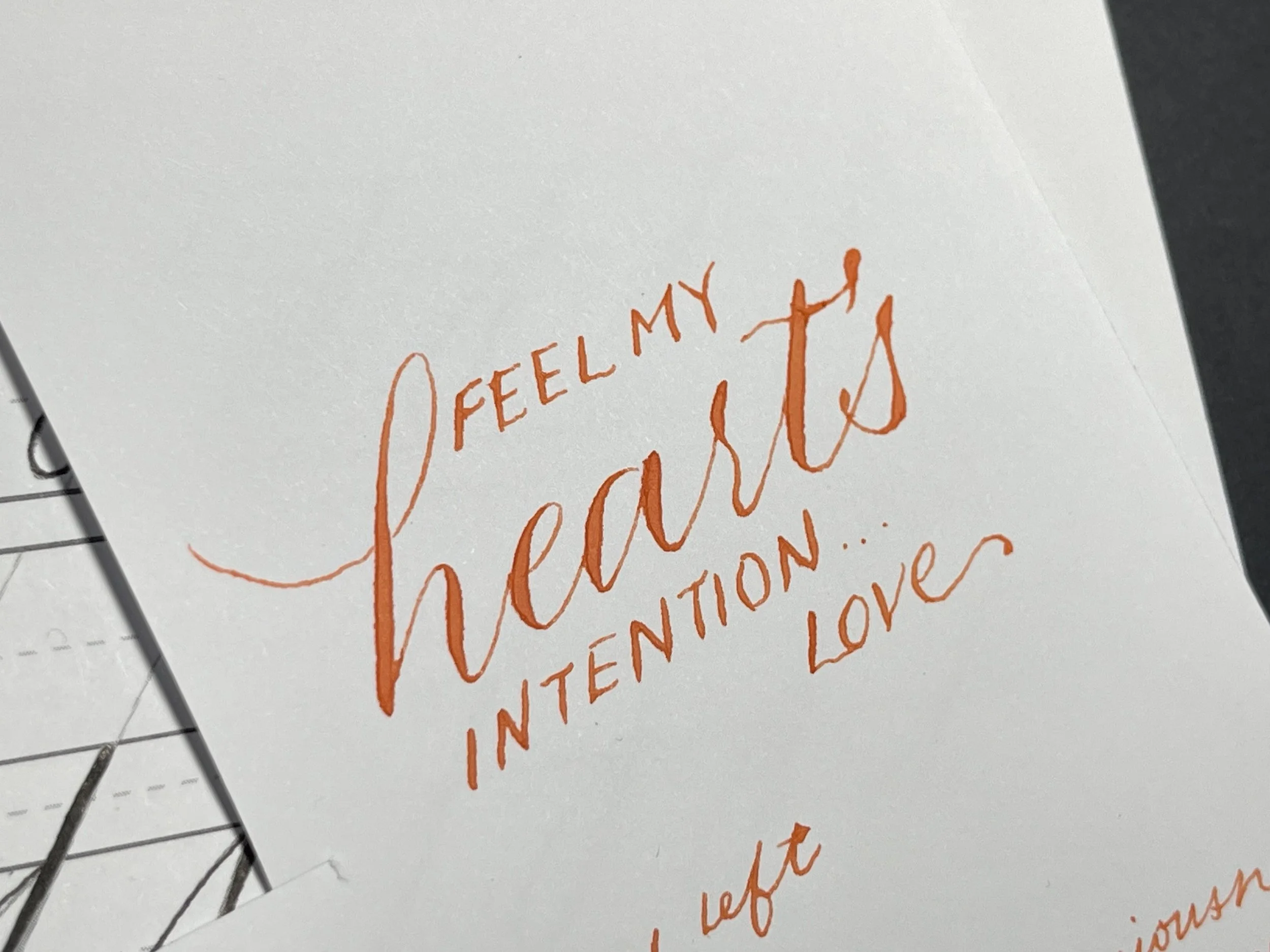 Lyrics handwritten in modern calligraphy: Feel my heart's intention, love