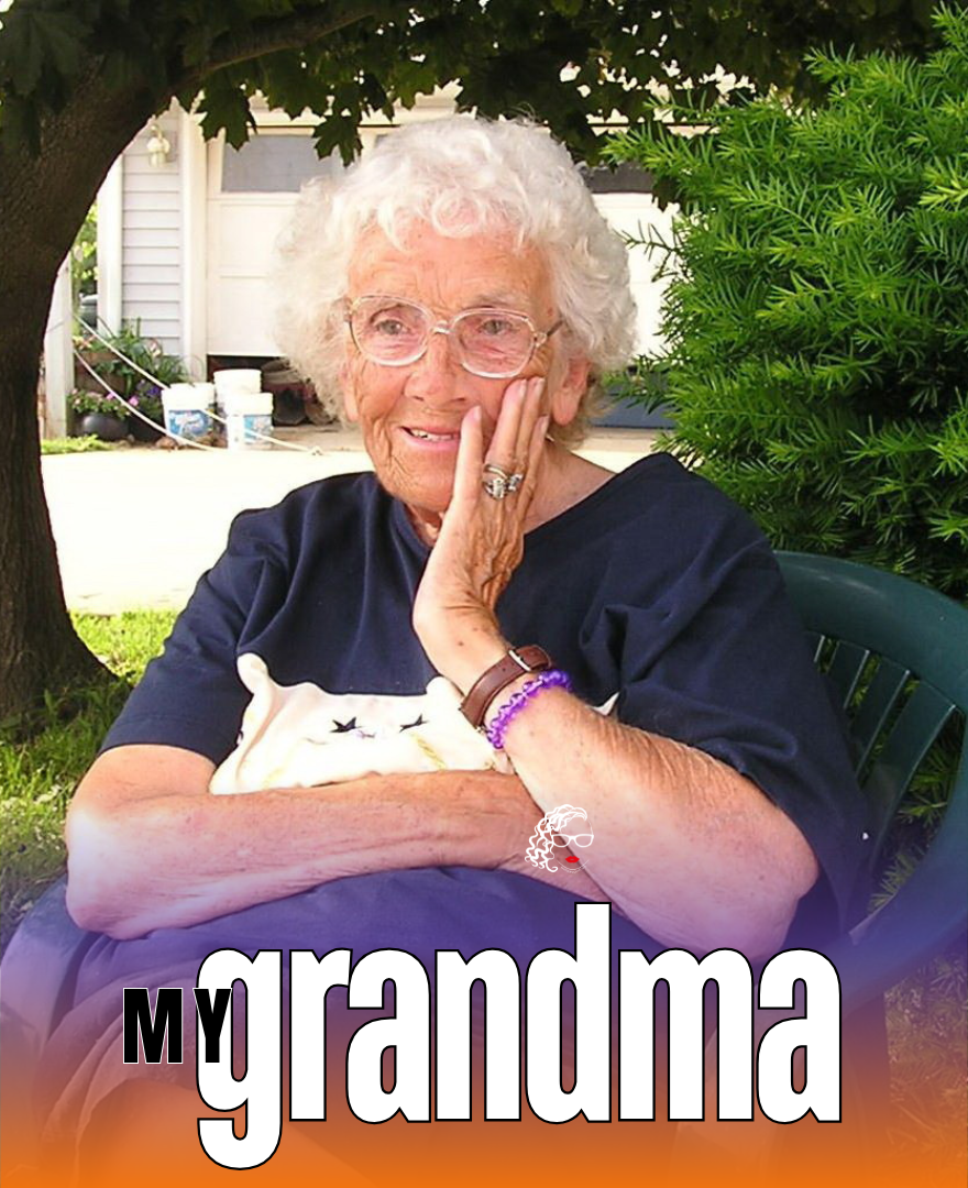 A smiling elderly woman with curly white hair and glasses, sitting outdoors under a tree, resting her head on her hand. There is greenery and a house in the background. The words "my grandma" are written at the bottom of the image.