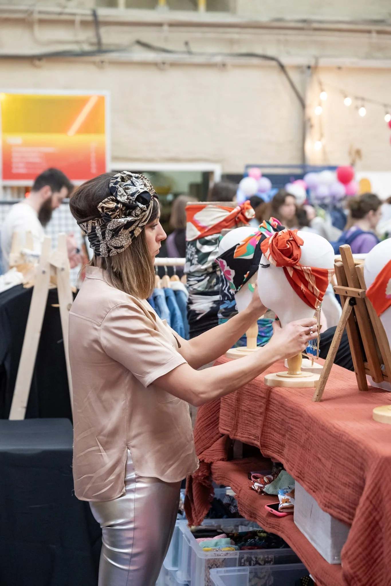 femme avec un bandeau qui tient la tête d'un mannequin avec un bandeau dessus