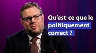 Une personne avec des lunettes, portant un costume, assise devant un fond violet avec le texte en français 'Qu'est-ce que le politiquement correct ?'
