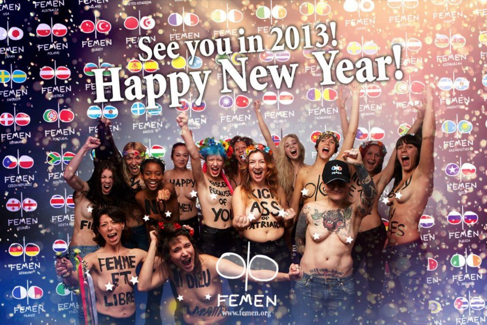 Groupe de femmes souriantes et célébrant leur liberté, avec des messages écrits sur leur corps, lors d'un événement de la FEMEN pour célébrer le Nouvel An 2013.