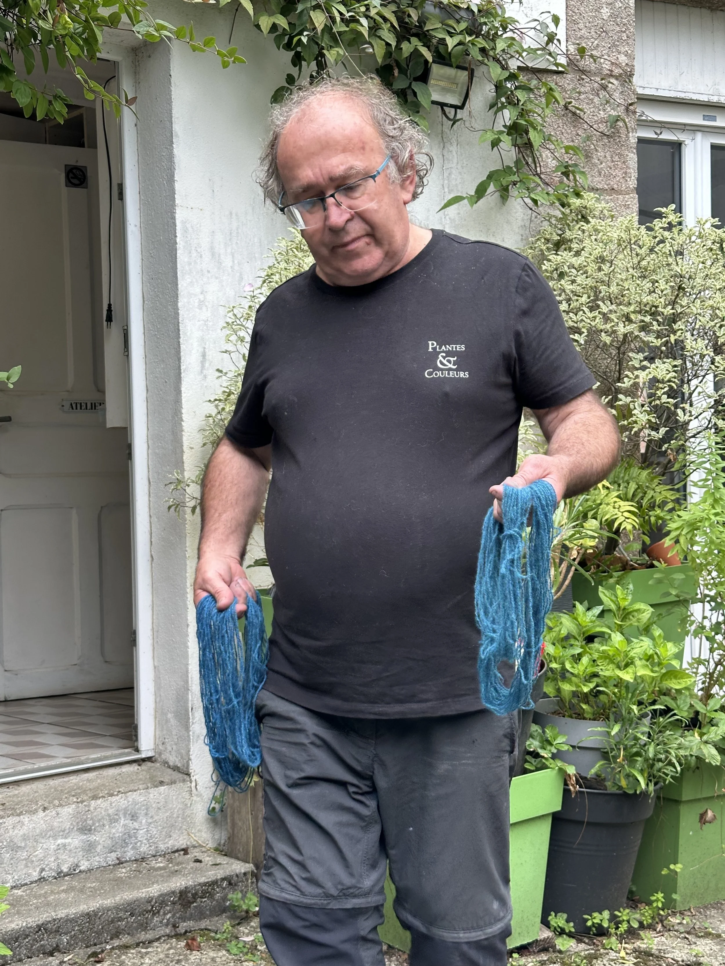Michel holding wool yarn dyed with Saxon Blue