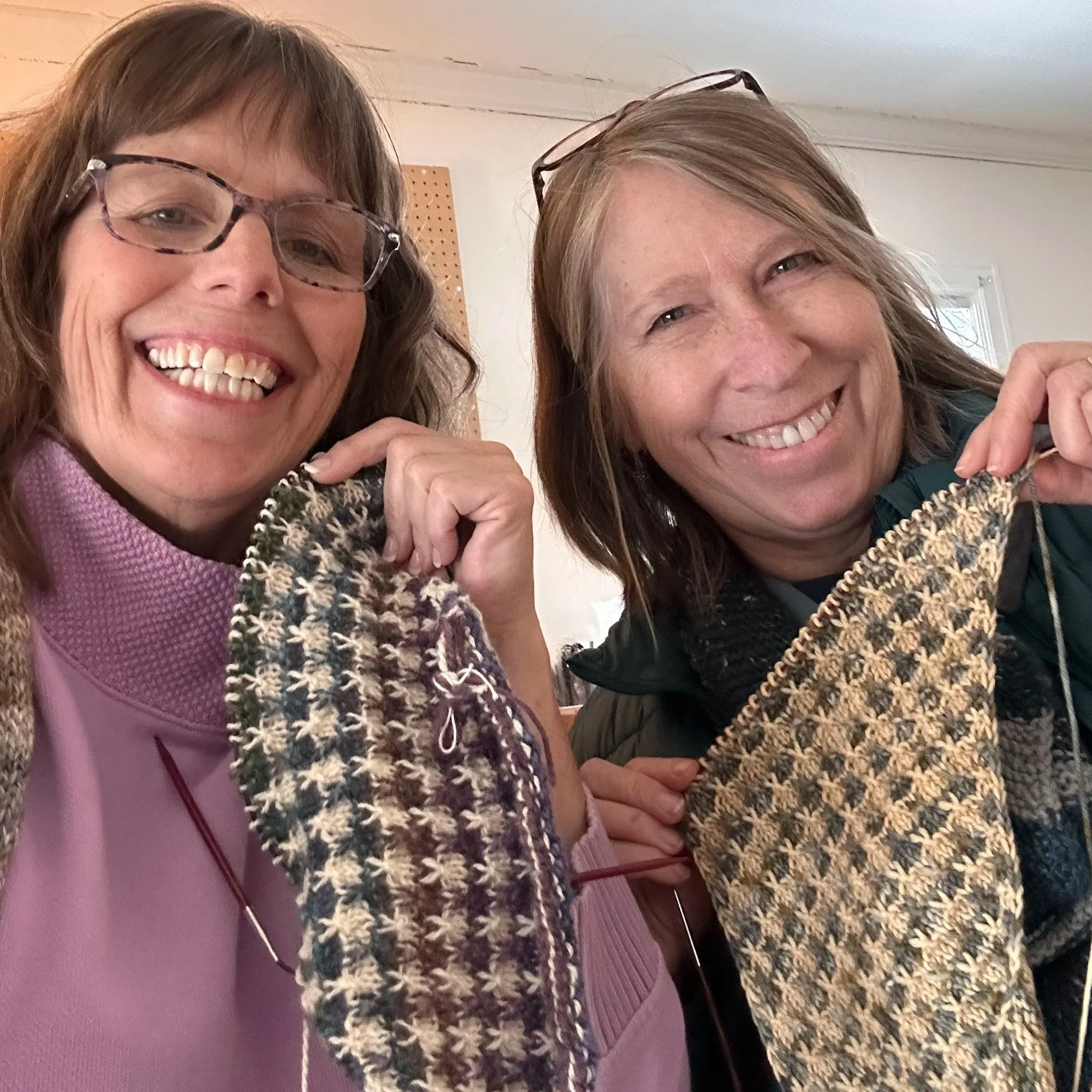 Michelle and Linda holding a work in progress - a colorwork, knit cowl.