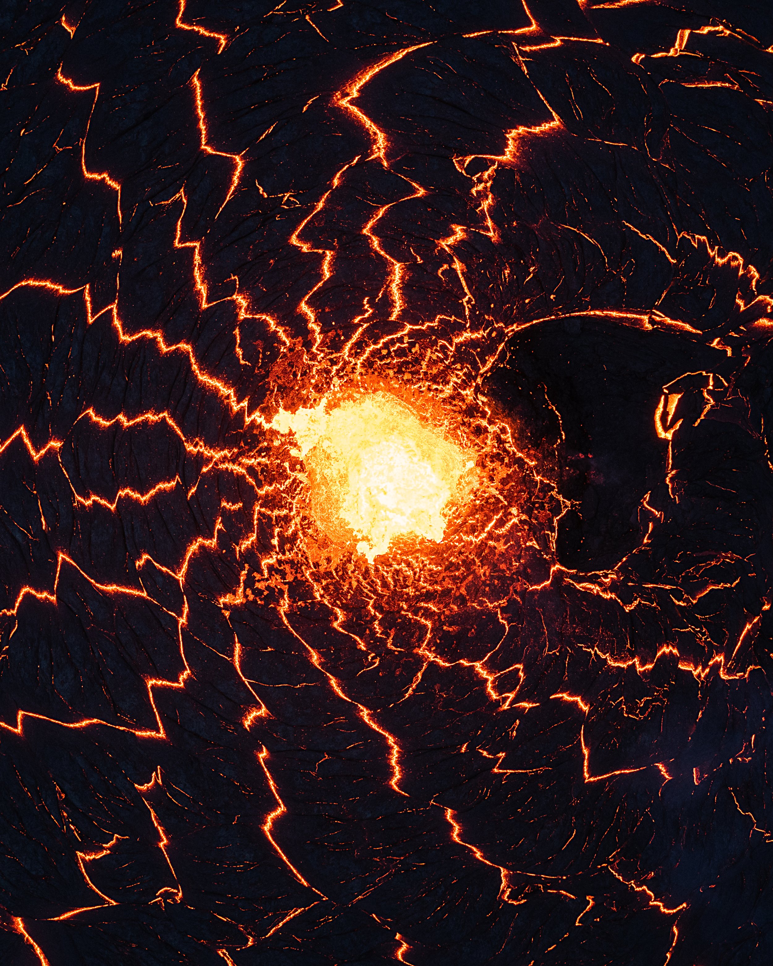 Lava flowing and cracked Earth's surface with glowing red and orange fissures.