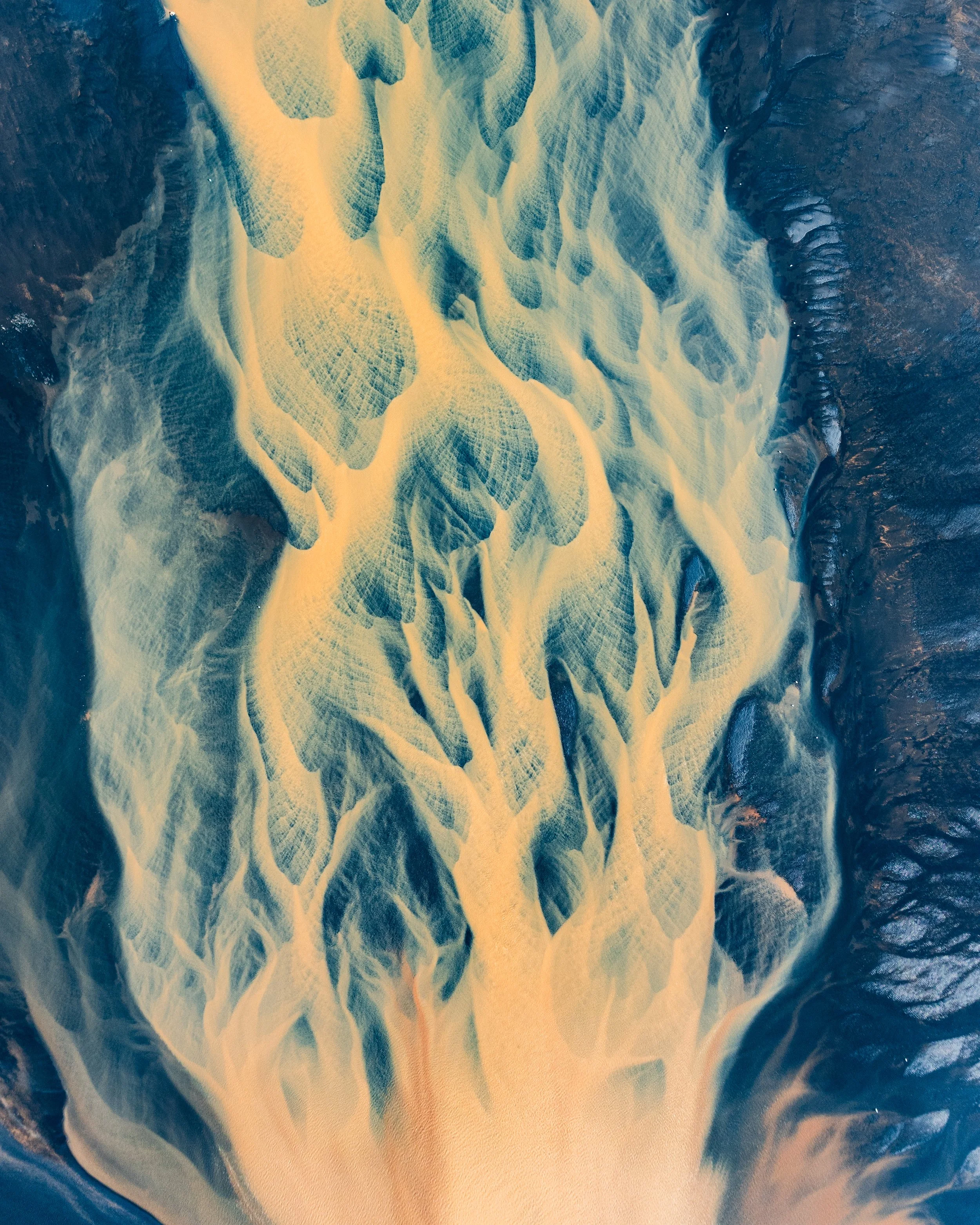 Aerial view of a river delta with branching river channels and surrounding dark land.