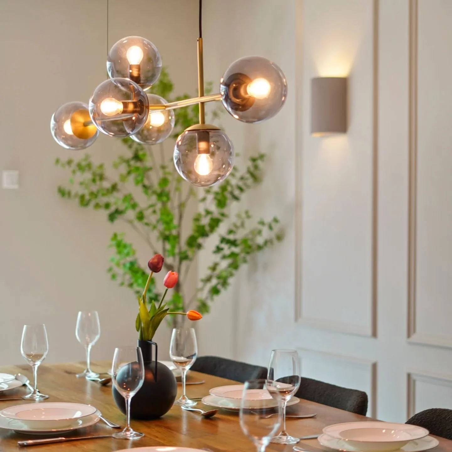 Sophisticated simplicity.

Everything in this dining space is brand new &mdash; from the custom wall paneling to the statement pendant lighting and carefully styled table setting. 

This project is all about layering textures, lighting, and clean arc