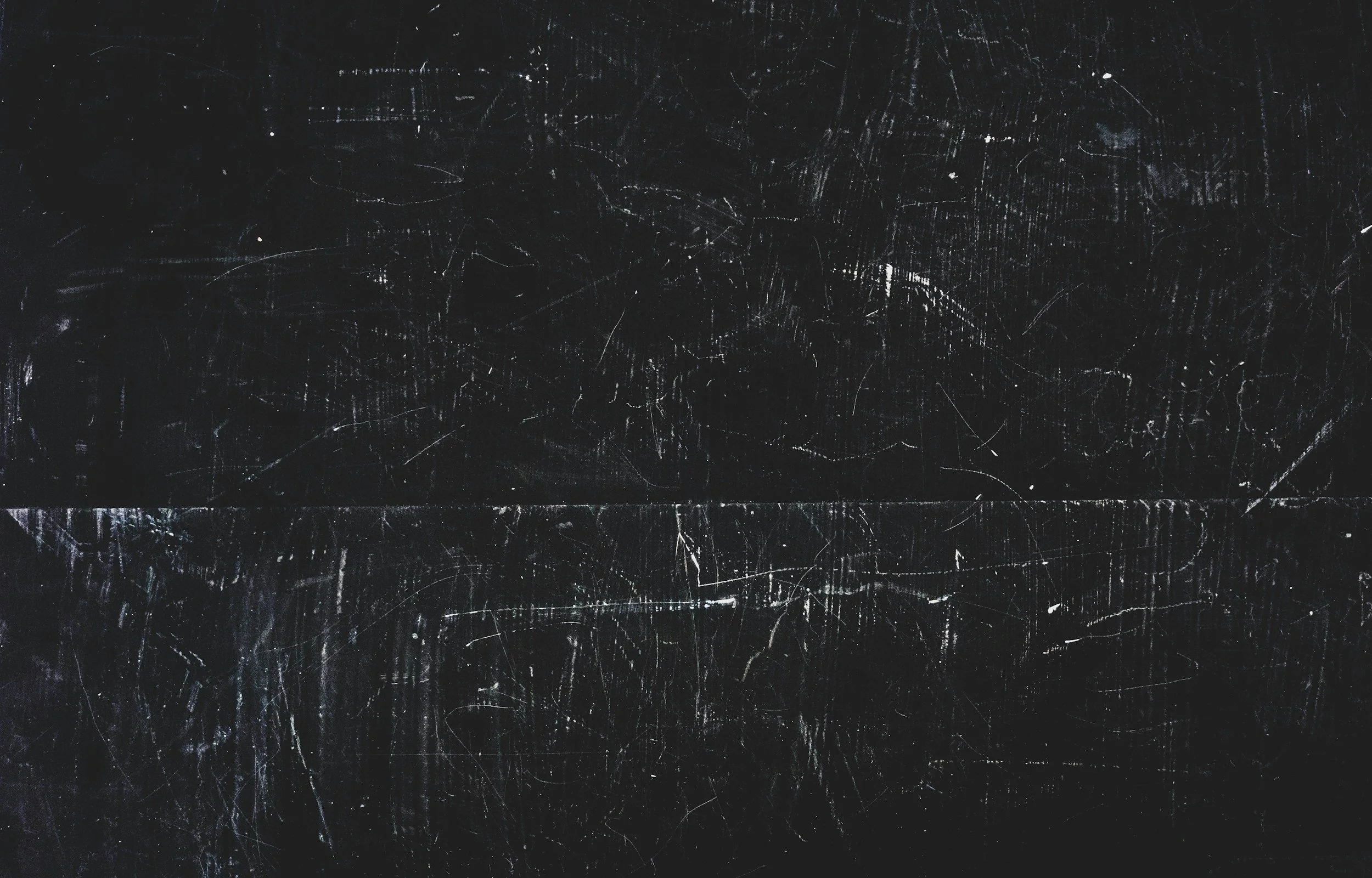 Black surface with numerous scratches and marks.