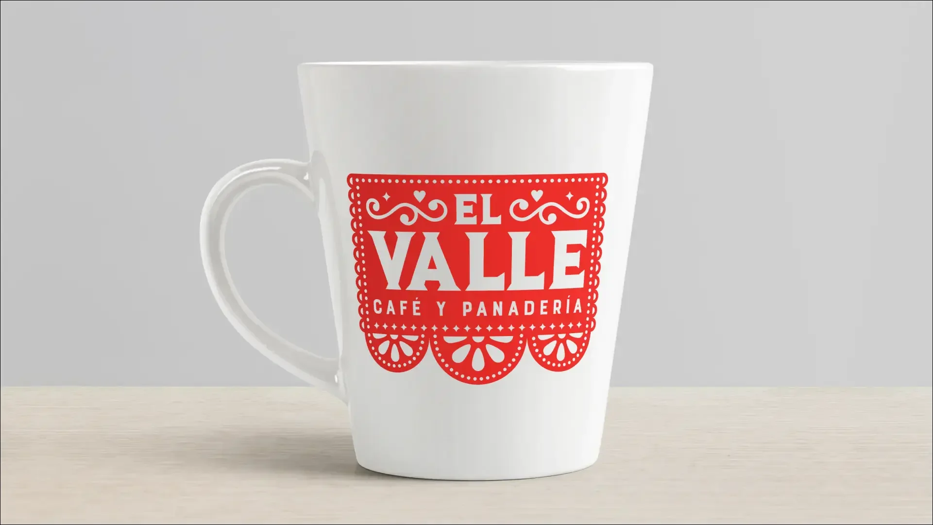 White mug printed with the red El Valle Café y Panadería logo.