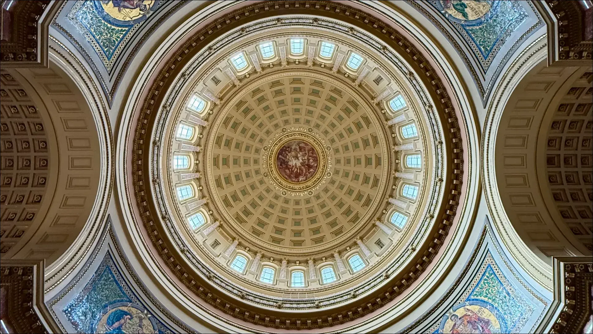 Ornate domed ceiling with columns, windows, paintings, and decorative details.