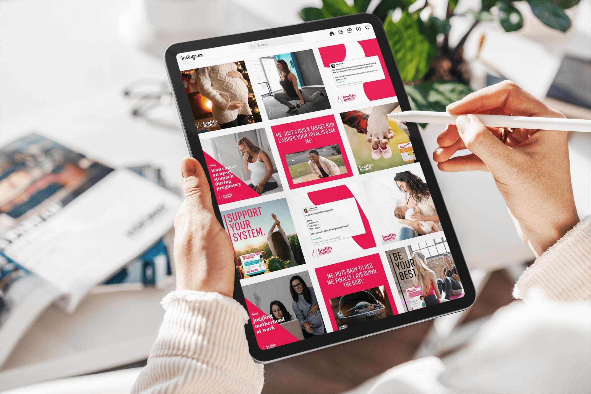 Person holding a tablet displaying an Instagram feed with health, pregnancy, and motherhood-related posts in pink and white colors.