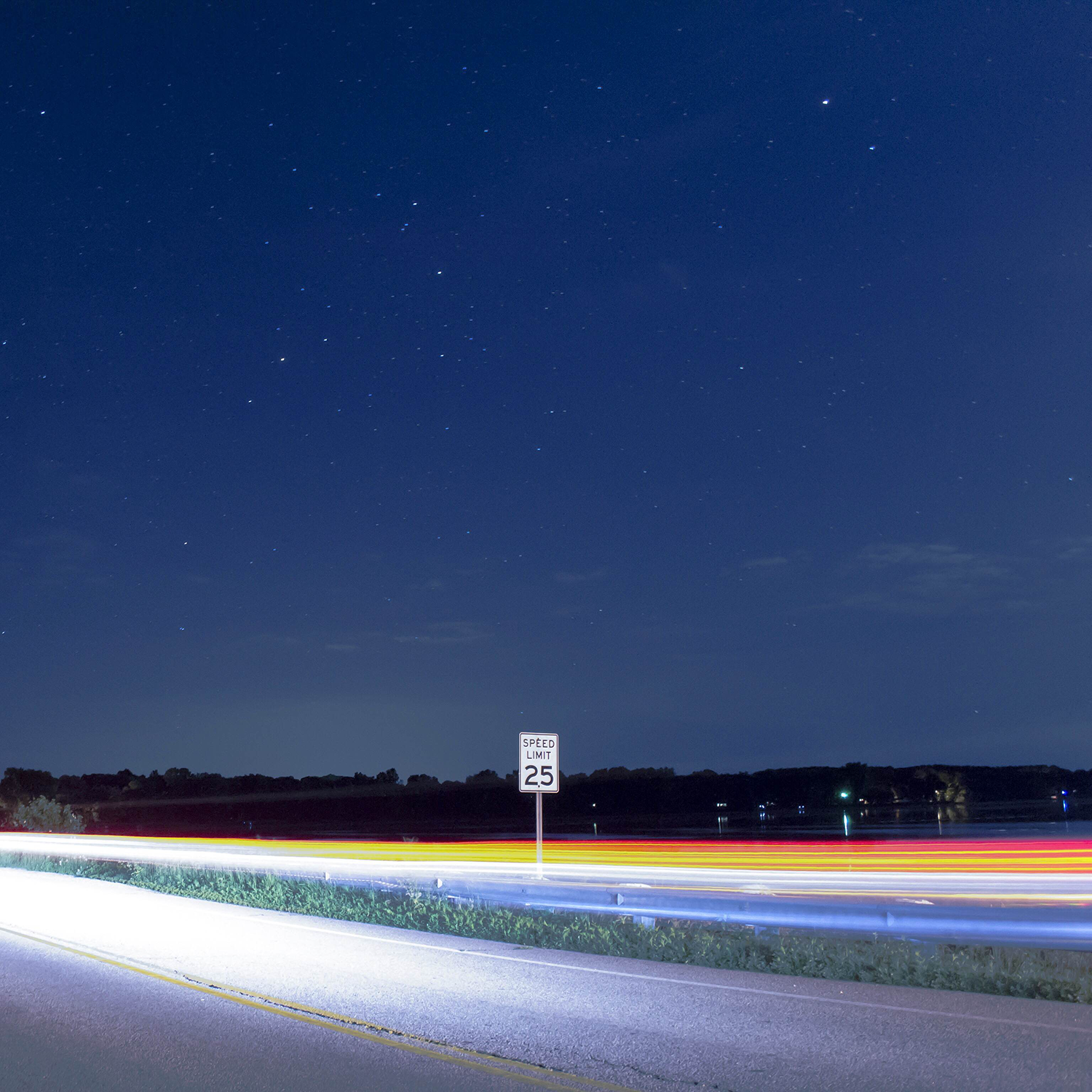 Long-exposure vehicle light trails beneath a starry sky
