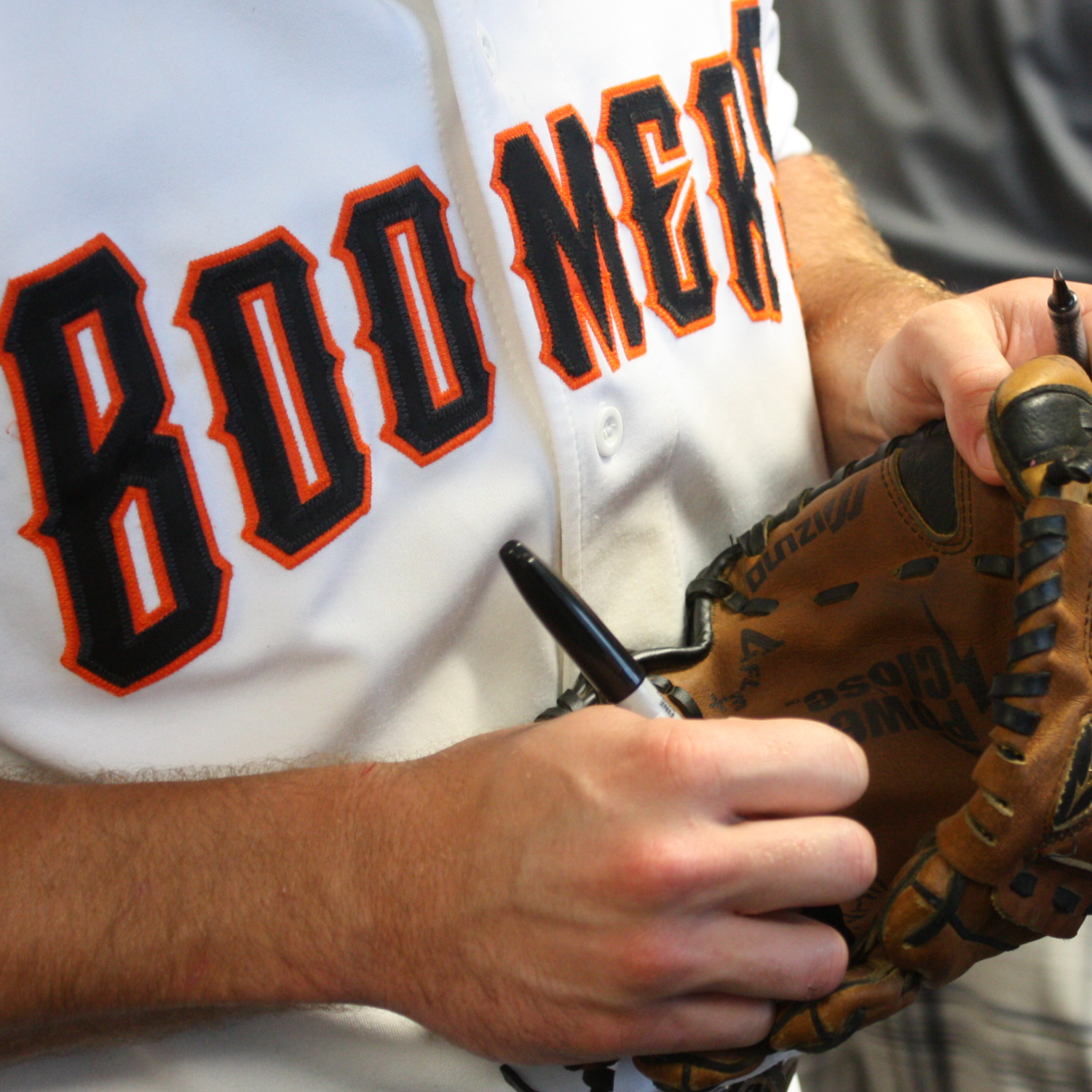 Close-up of a Boomers baseball jersey and glove