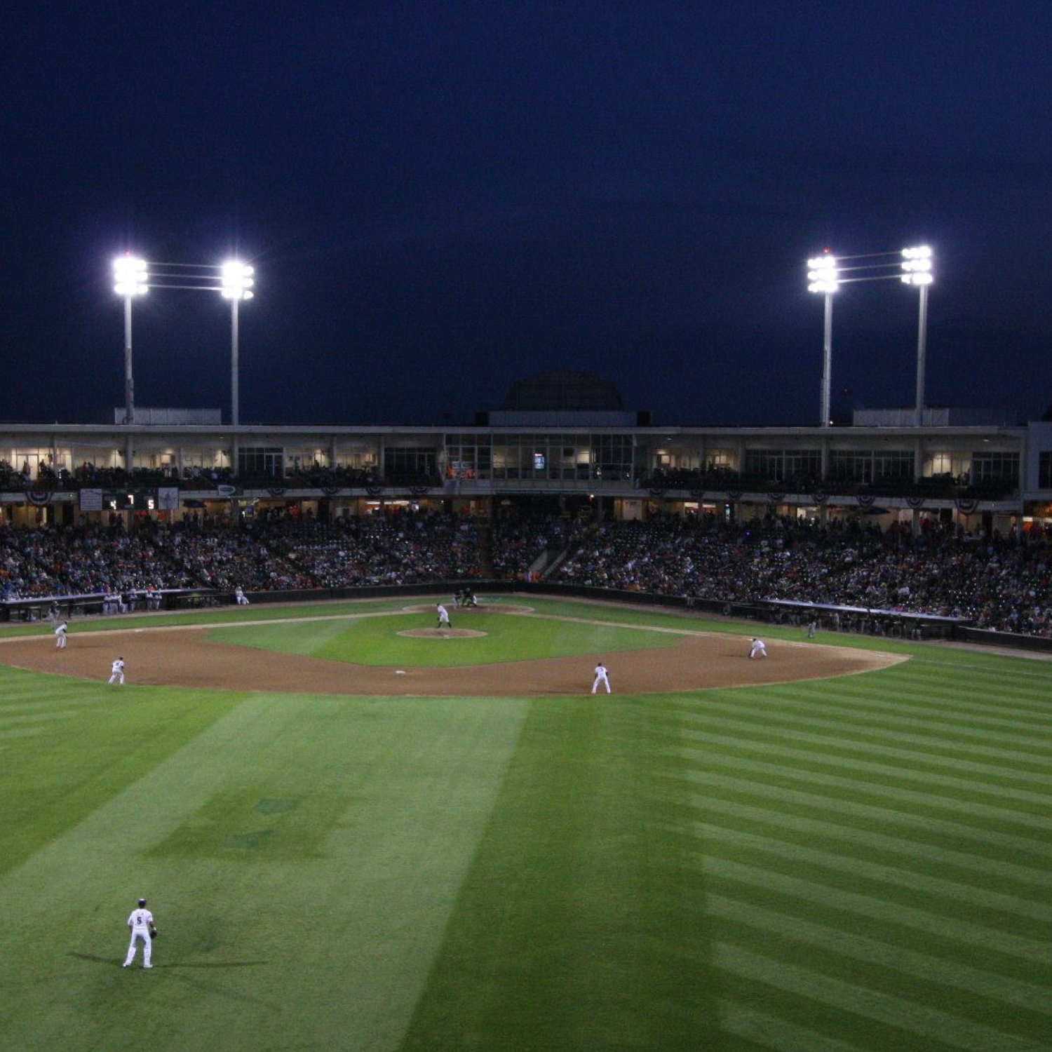 Baseball game under stadium lights at night