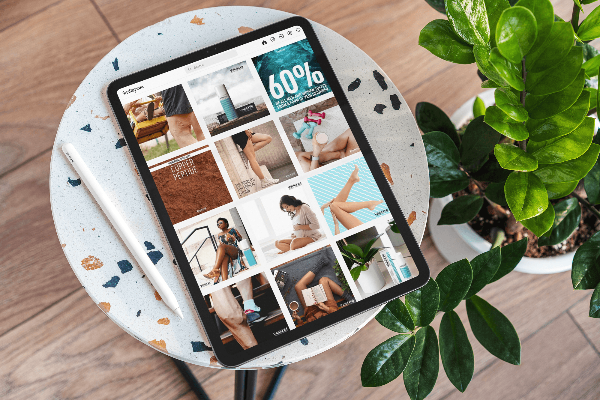 Tablet on a round speckled table displaying an Instagram feed with health and fitness-themed images, next to a white pen.