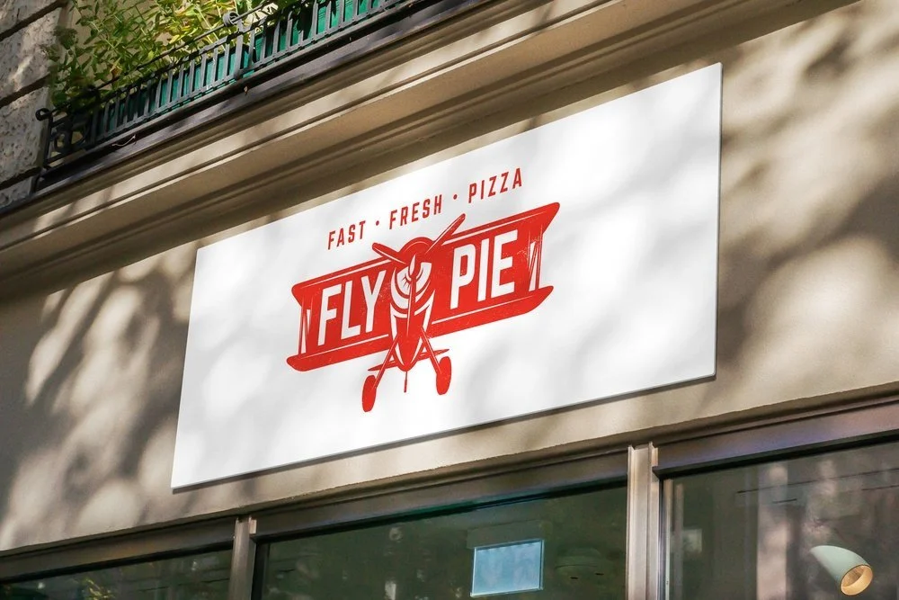 Fly Pie restaurant sign with red text and graphic of a slice of pie with airplane elements, on a white background.