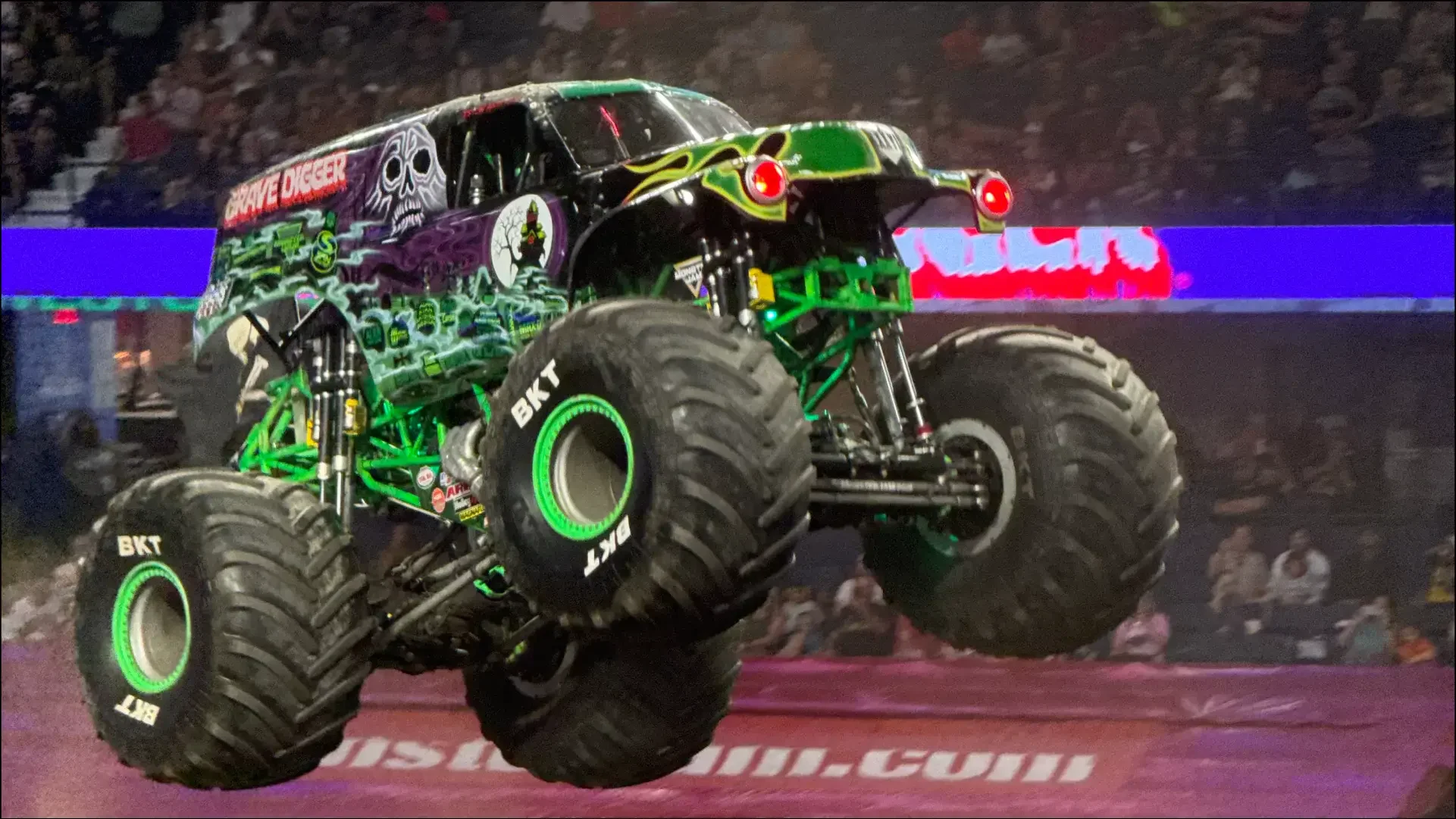 Black-and-green monster truck performing at an arena event.