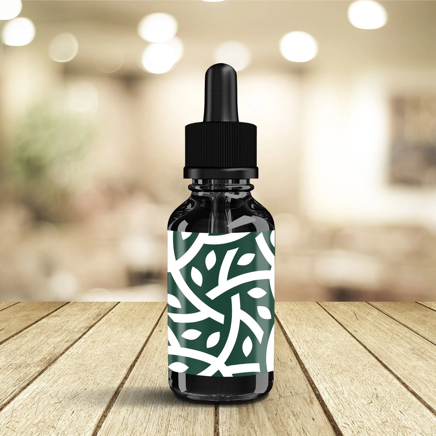 A small dropper bottle with a green and white abstract leaf pattern on the label, placed on a wooden surface with a blurred indoor background.
