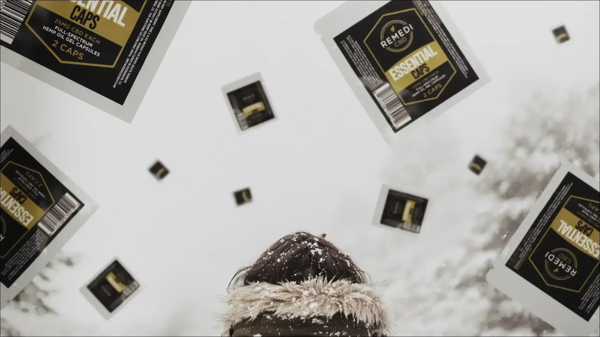 Remedy CBD essential capsule boxes arranged on snow.