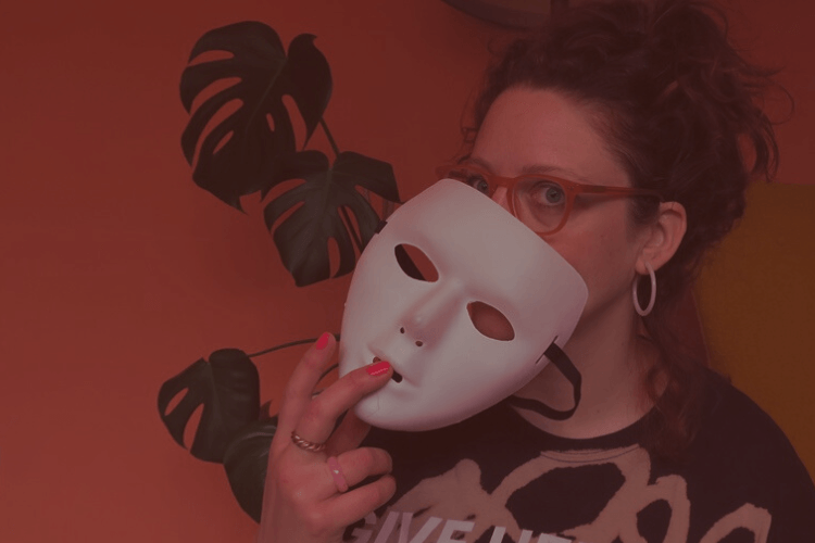 Gutsy founder Susannah holds a white drama mask half covering her face
