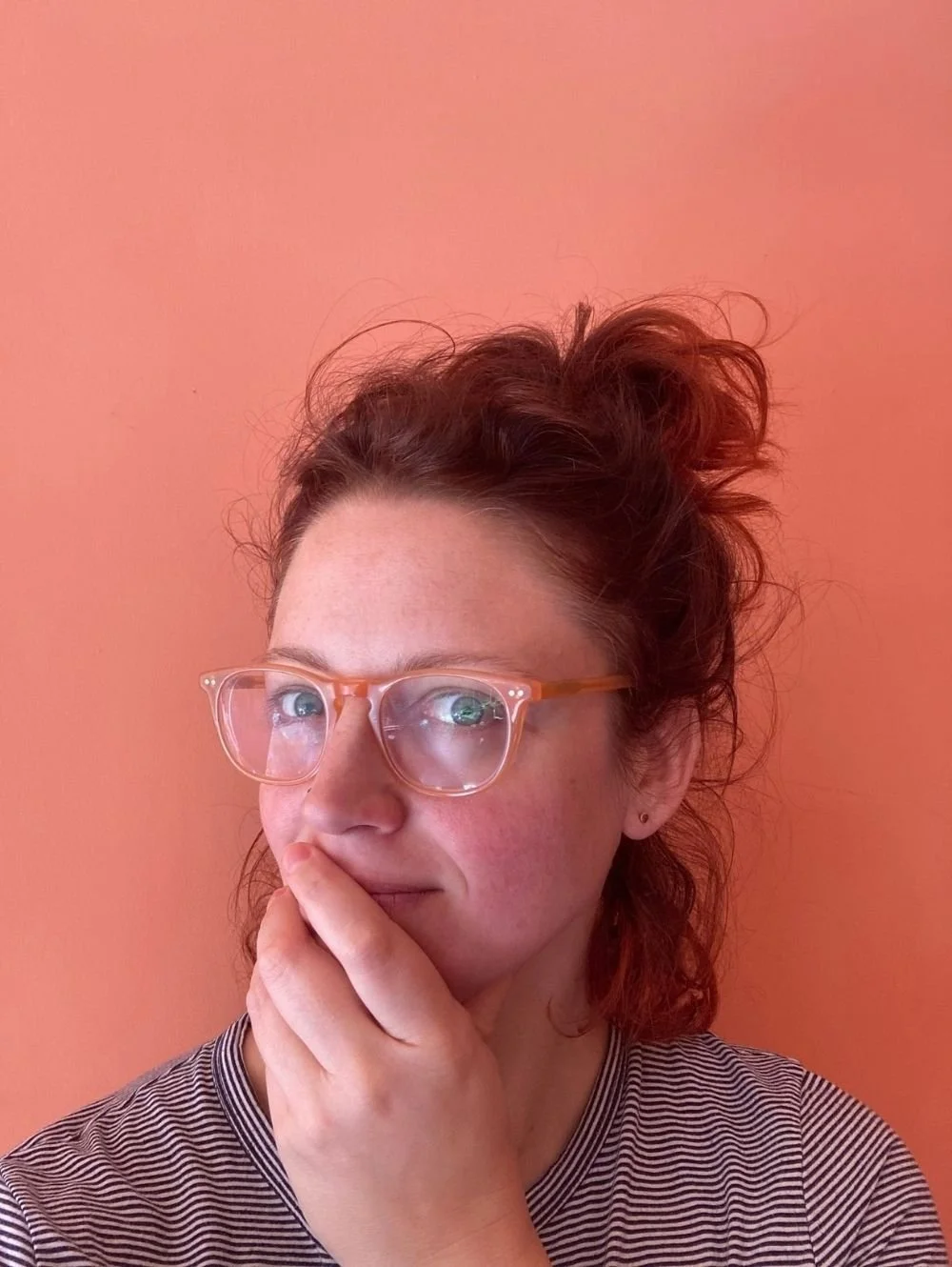 Gutsy founder Susannah with hand over mouth, eyes to the side, looking thoughtful and mischievous