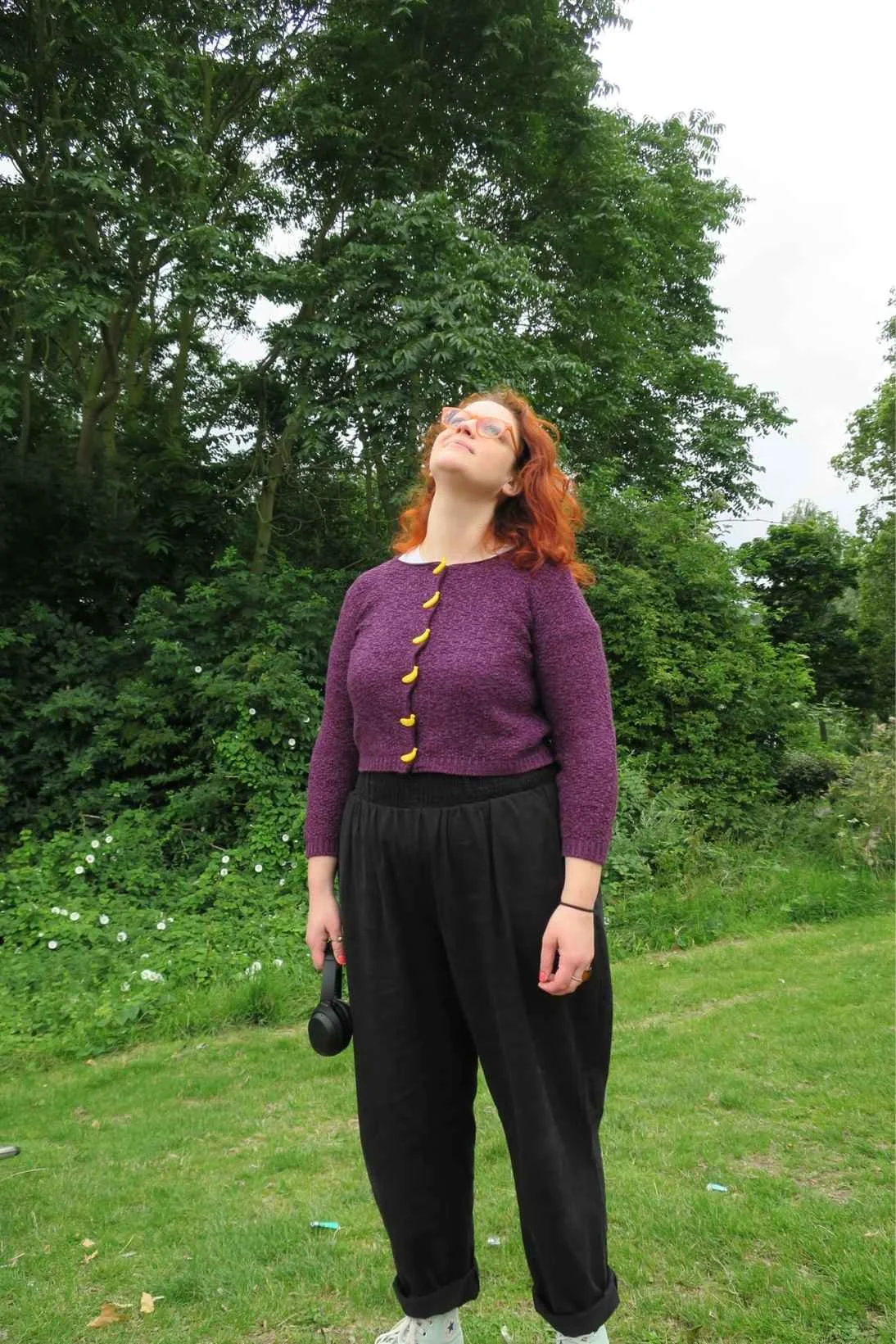  Susannah stands in the park looking up towards the sky smiling 
