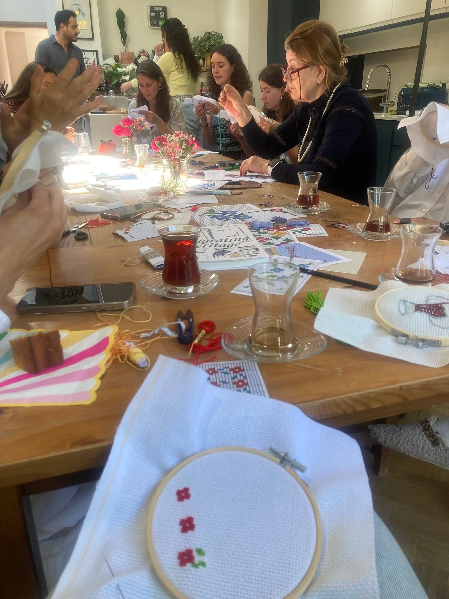 Making cross-stitch flowers at a table of women also doing cross-stitch, drinking Turkish tea and chatting