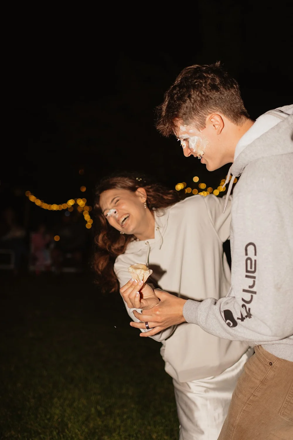 couple plays with cake during wedding reception