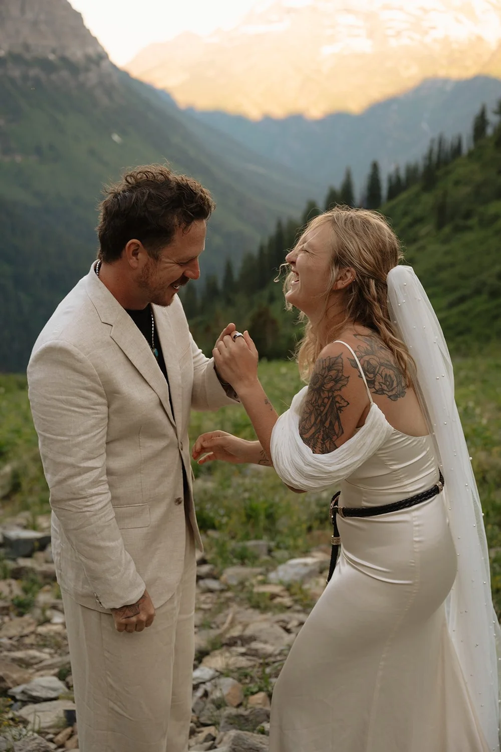 couple laughs together at Glacier National Park elopement