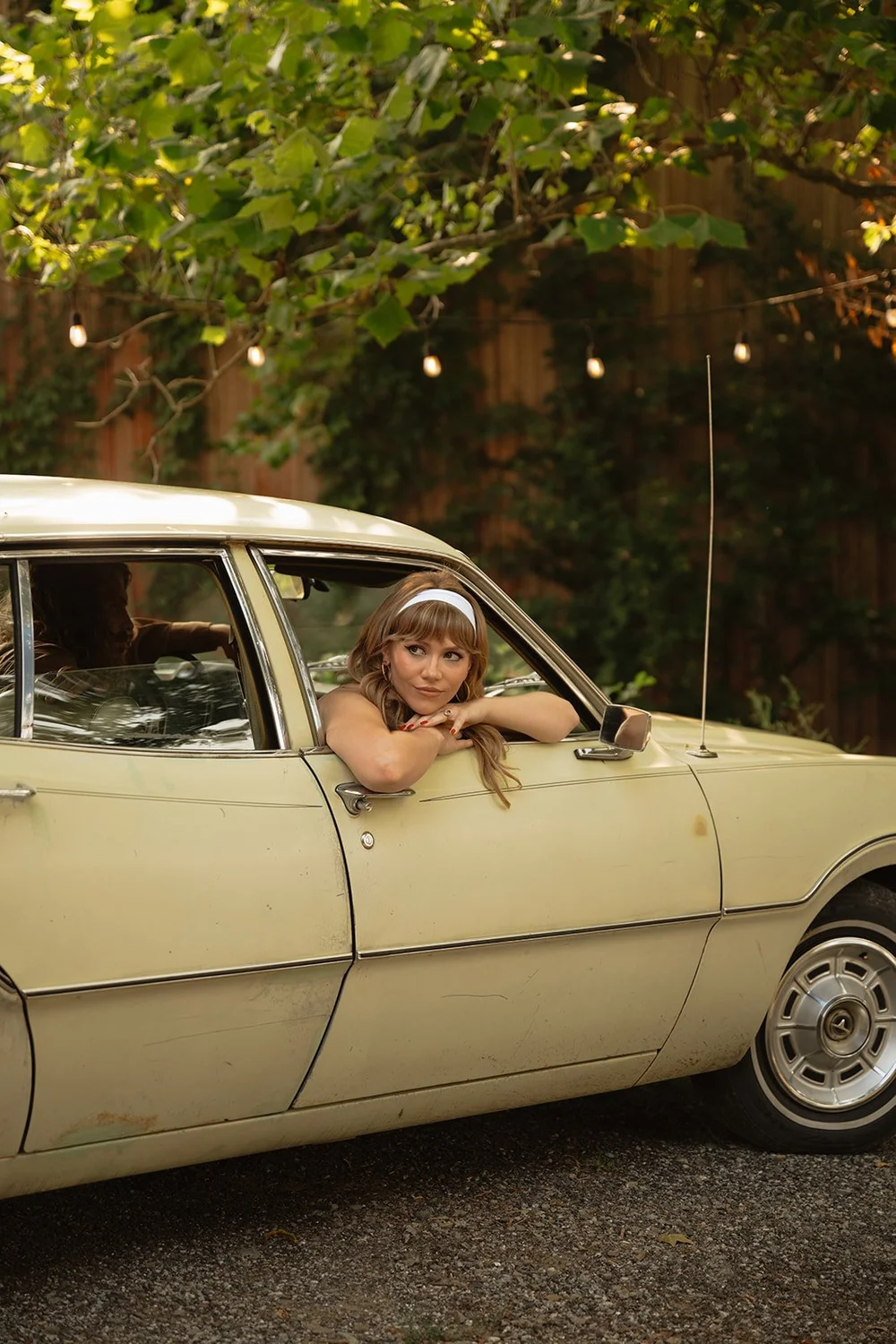 woman poses in vintage car during engagement session