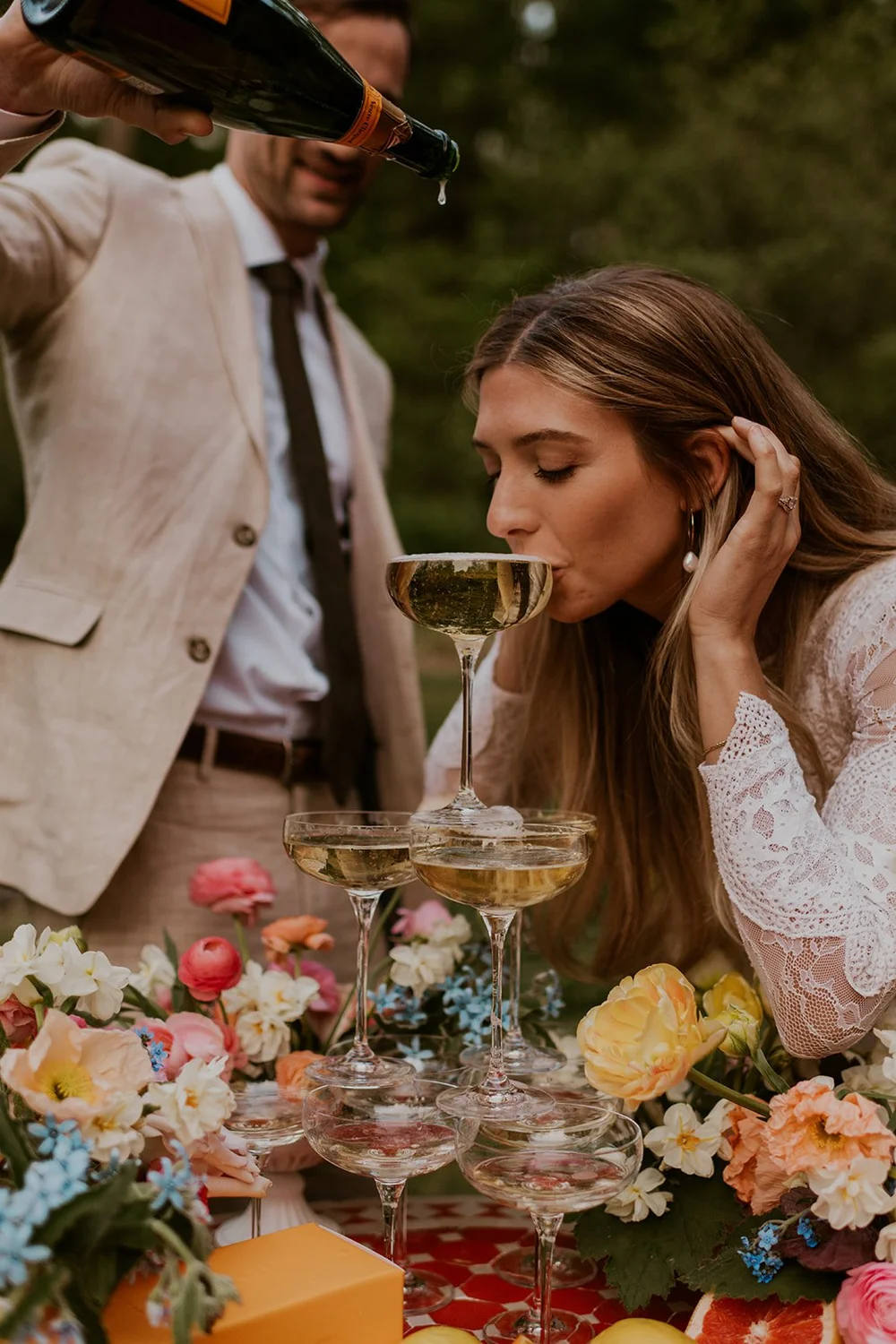couple sips on champagne pouring tower