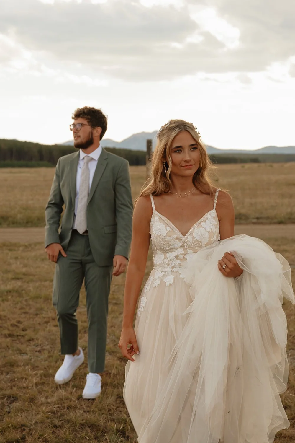 couple walks field at sunset elopement