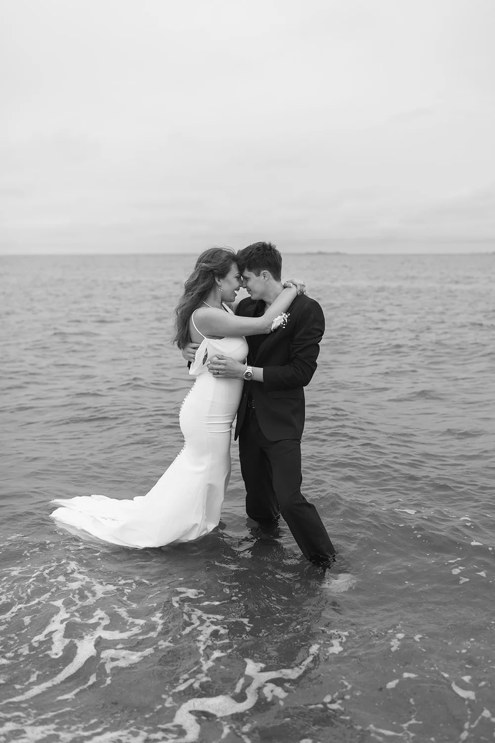 couple embraces in ocean at beach elopement