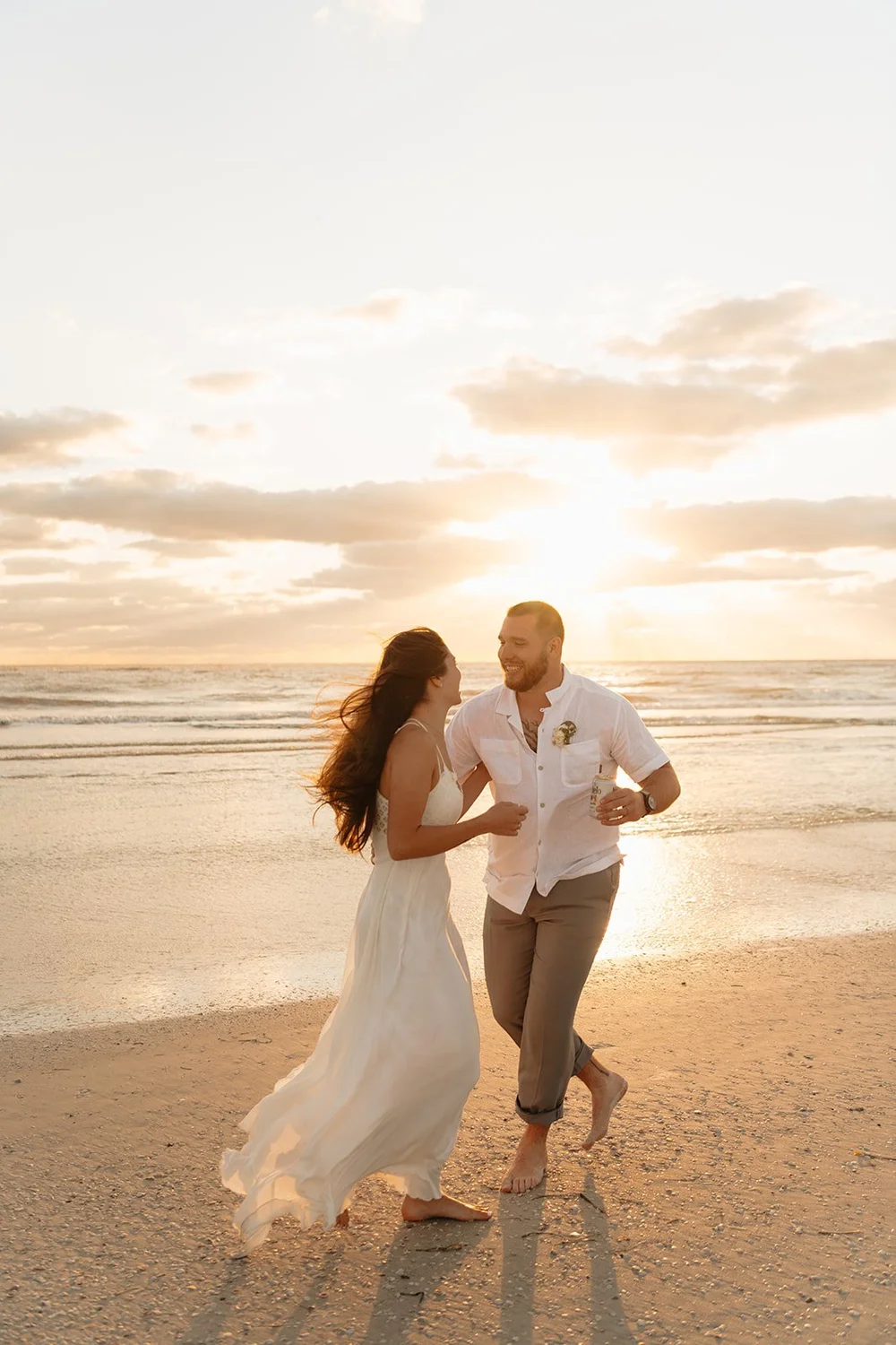 couple plays around at sunset beach elopement