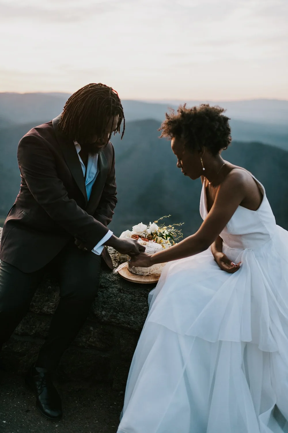 couple cuts wedding cake at elopement