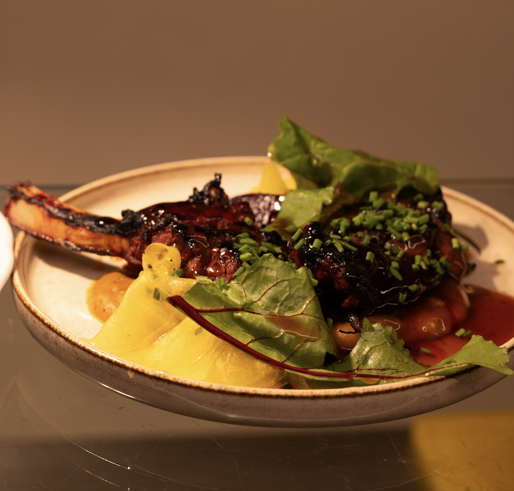 Plat de viande grillée avec légumes verts et purée de pommes de terre, présenté dans une assiette