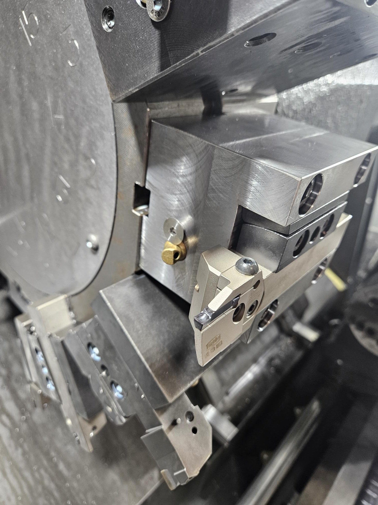 Close-up of a metal mechanical component with various machined parts and bolts.