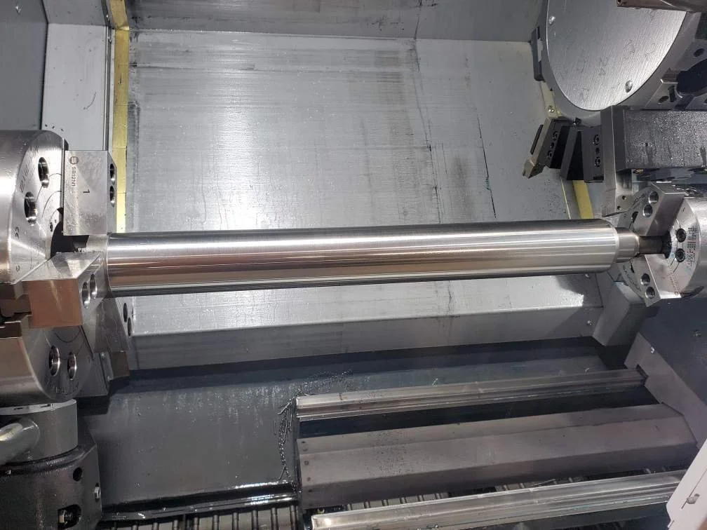 Metalworking lathe holding a cylindrical metal piece