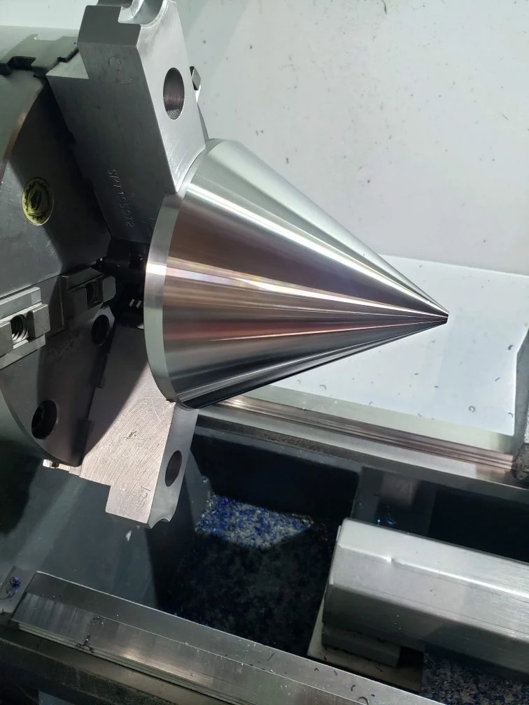 Metal cone being machined on a lathe