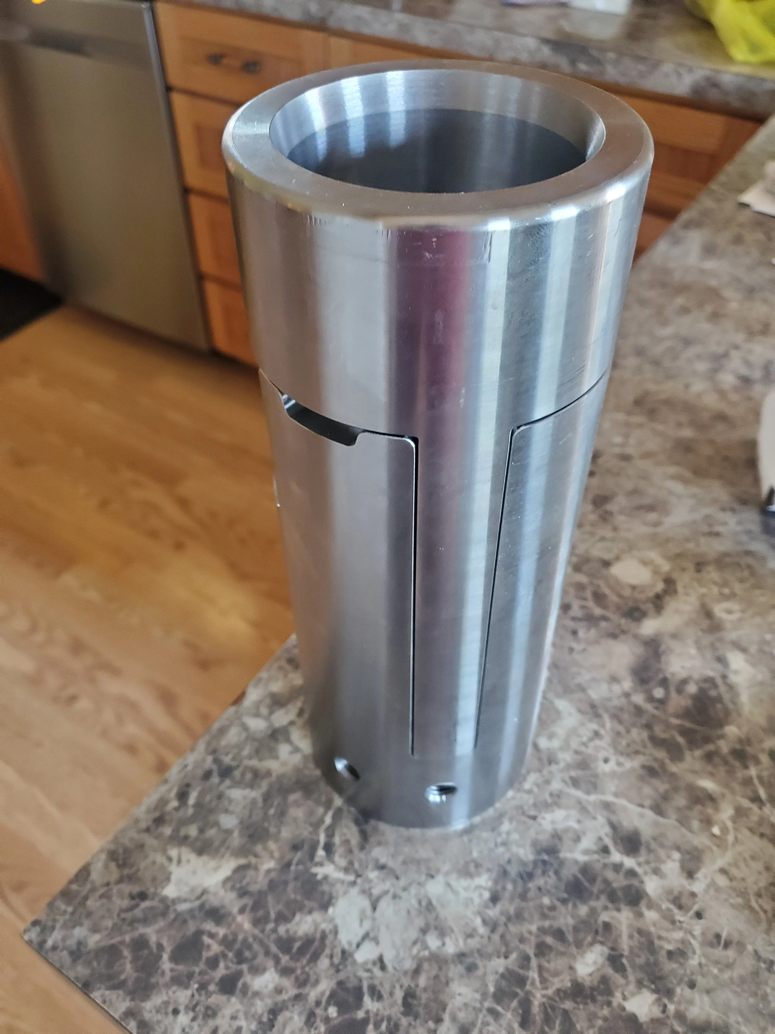 Metal cylindrical component with openings on a marble countertop