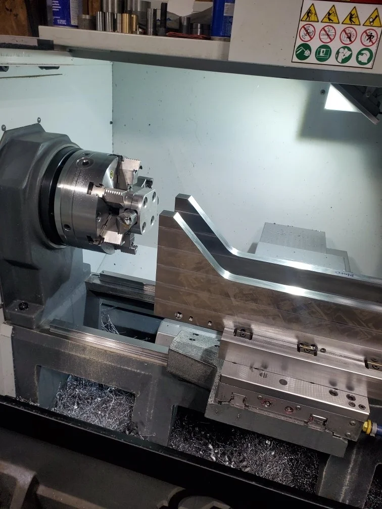 Metalworking CNC machine with lathe chuck and tool holder.