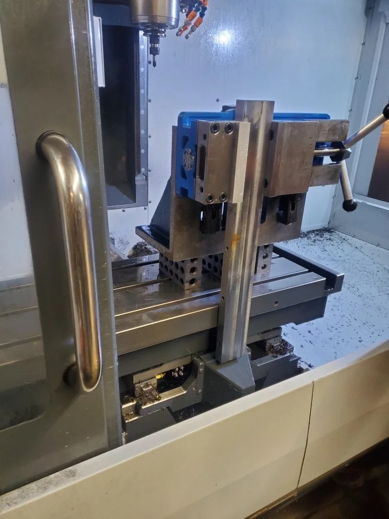 CNC machine with a metal workpiece secured on the table