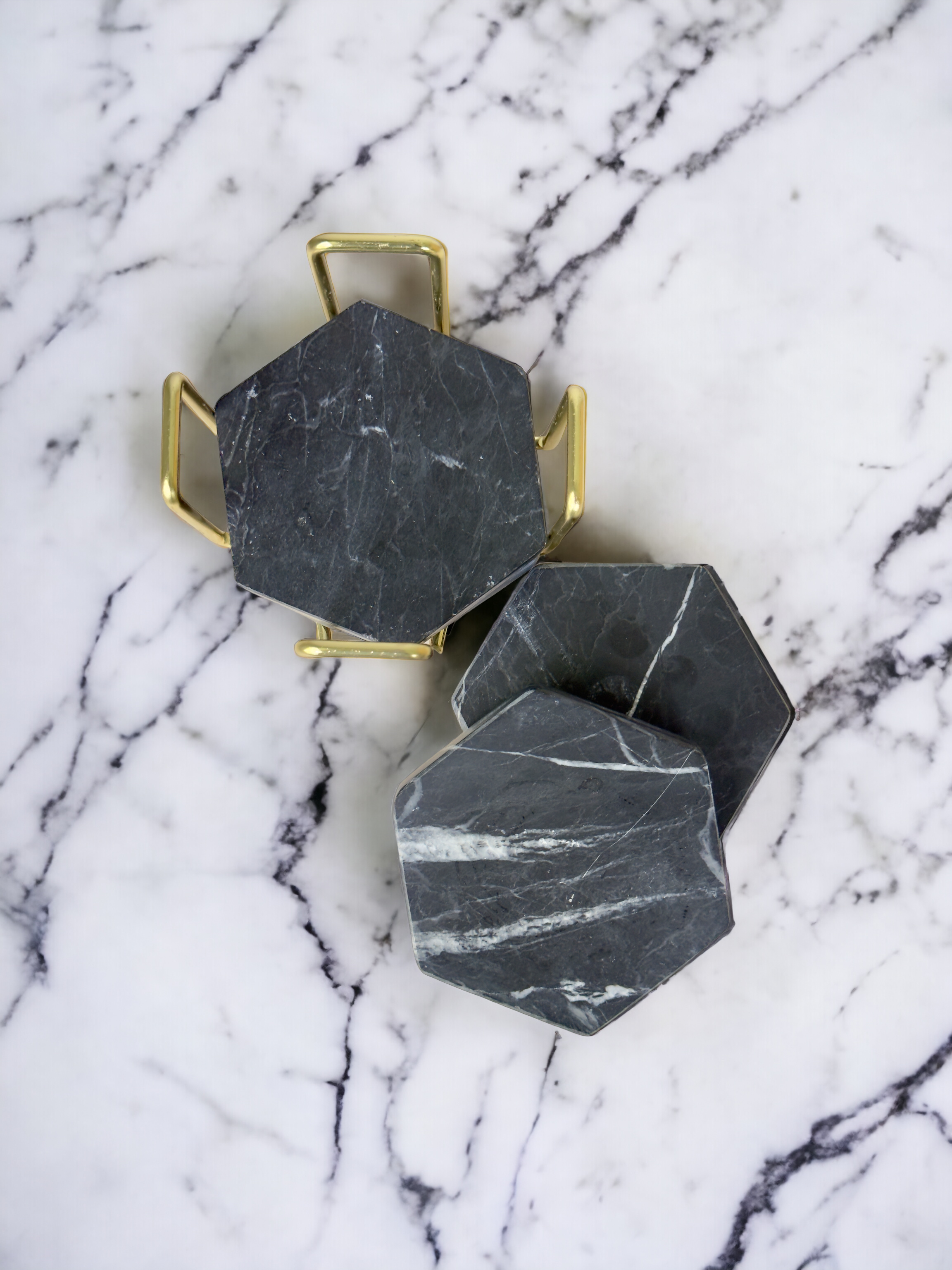 A glass jar filled with moss and twigs holds a bouquet of pink and white flowers, including roses and hydrangeas, on a wooden surface with a plain white wall background.